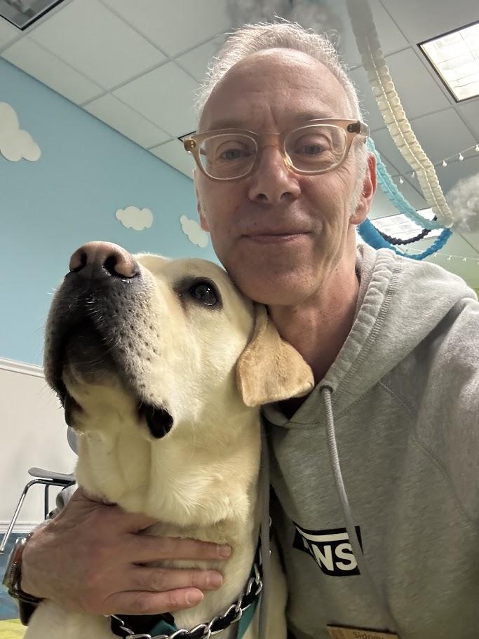 A selfie of Sid, the librarian, and Teddy(the Certified Therapy Dog). 