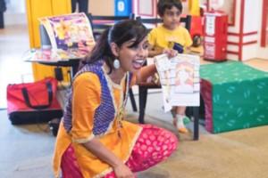 A woman reading a book from Bollywood & Culture Grove. 
